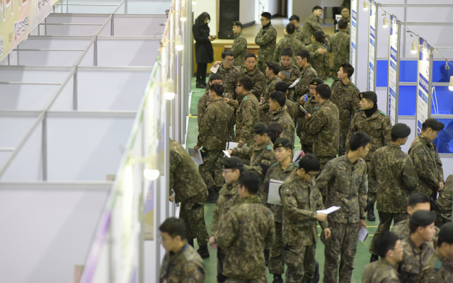 육군 제17보병사단 장병들이 방위사업청과 인천지방중소벤처기업청 주관으로 2018년 12월 인천에서 열린 일자리박람회에서 기업들의 홍보관을 찾아 취업 정보를 듣고 있다. /연합뉴스