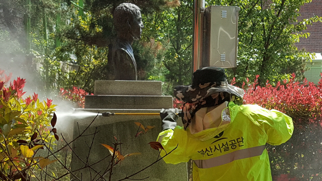 25일 동래구 낙민초등학교 교정에 있는 의인 이수현 동상을 부산시설공단 직원이 고압세척 장비로 청소하고 있다./사진제공=부산시설공단