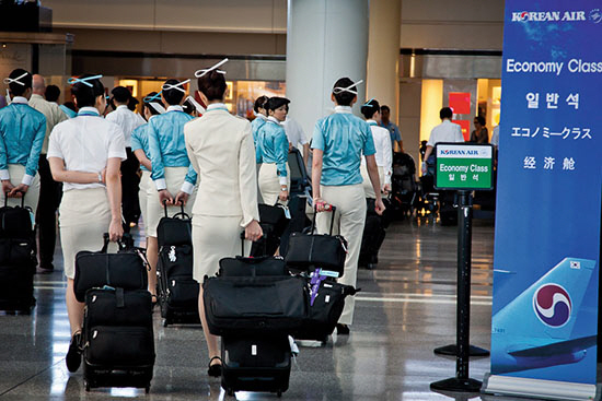 비행기 탑승을 앞둔 대한항공 승무원들이 출국심사를 마치고 인천국제공항을 빠져나가고 있다./연합뉴스