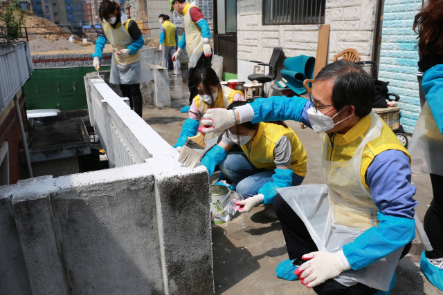 황규연 한국산업단지공단 이사장이 26일 임직원과 함께 대구 소재 홀몸 오르신 거주주택을 찾아 난간 벽에 페인트칠을 하고 있다. /사진=산단공