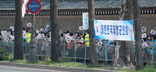 재향군인회 회원들이 27일 오전 서울 광화문 앞에서 남북정상회담 성공 기원 한마음대회에 참여해 태극기를 들고 판문점으로 향하는 문재인 대통령 일행을 기다리고  있다./연합뉴스