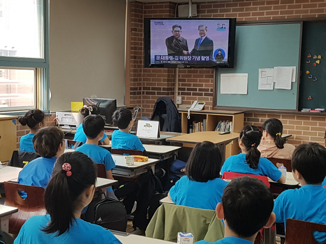 서울 양천구 신은초등학교 4학년 학생들이 27일 문재인 대통령과 김정은 북한 국무위원장이 악수하며 기념촬영하는 모습을 TV로 지켜보고 있다. /백주연기자