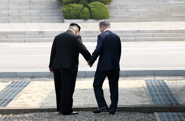 문 대통령과 김 위원장이 손을 맞잡고 군사분계선을 넘는 모습.    　 /한국 공동 사진기자단