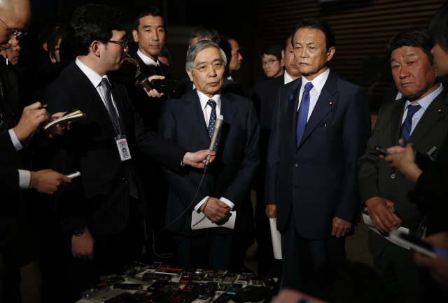 구로다 하루히코 일본은행(BOJ) 총재(가운데)가 연임에 성공해 두 번째 임기를 시작한 지난 9일(현지시간) 도쿄 총리관저에서 아베 신조 총리와 회동 직후 기자들과 만나고 있다./도쿄=AFP연합뉴스
