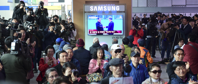 남북 정상회담이 열린 27일 군사분계선을 넘어온 김정은 북한 국무위원장과 문재인 대통령이 악수하는 역사적인 장면을 서울역에서 TV로 지켜보던 시민들이 감격에 겨워 박수를 치고 있다.  /송은석기자