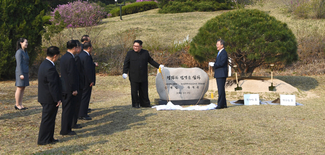 문재인 대통령과 북한 김정은 국무위원장이 27일 오후 판문점 군사분계선 소떼 길 인근에서 소나무 공동식수를 마친 뒤 표지석을 제막하고 있다./연합뉴스