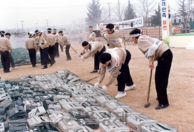 삼성전자 구미 사업장 직원들이 불량무선전화기에 대한 화형식 전 해머로 제품을 부수는 모습. /사진제공=삼성전자