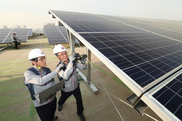 KT의 에너지 전문 인력들이 서울 관악구의 KT 구로타워 옥상에 구축된 태양광 발전소에서 시설을 점검하고 있다. /사진제공=KT