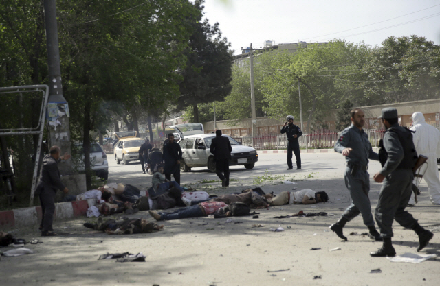 30일(현지시간) 아프가니스탄 수도 카불에서 발생한 자폭테러로 사망한 희생자들 주변을 경찰들이 수색하고 있다. /카불=AP연합뉴스