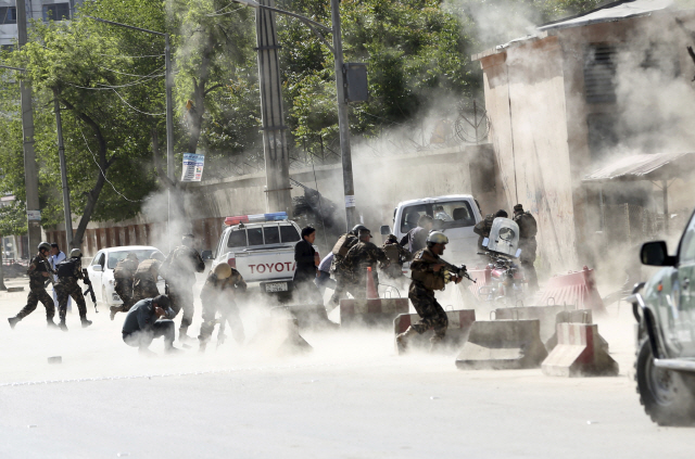 30일(현지시간) 아프가니스탄 수도 카불에서 연쇄 폭탄테러가 자행된 가운데 현장에 모여들던 보안군들이 두 번째 폭발이 발생하자 황급히 대피하고 있다. 이날 카불에서 일어난 두 차례의 폭탄테러로 최소 29명이 사망하고 49명 이상이 다쳤다. 사망자 중에는 AFP통신 소속 사진기자 샤 마라이도 포함됐다.  /카불=AP연합뉴스