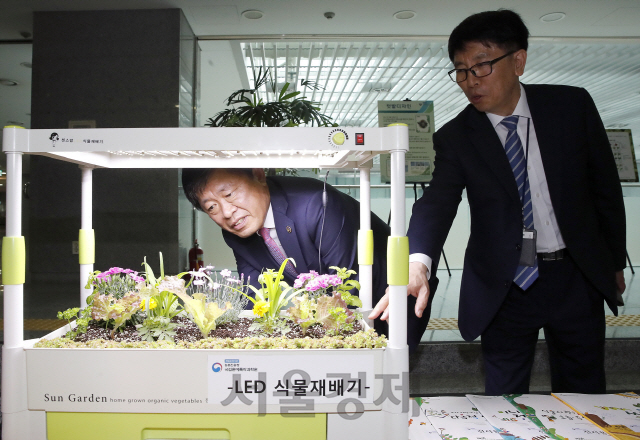 라승용(왼쪽) 농촌진흥청장이 1일 학교텃밭에 이용될 LED식물재배기를 살펴보고 있다. /사진제공=농진청
