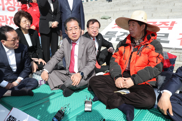 홍준표(왼쪽) 자유한국당 대표가 4일 오전 국회 본청 앞에서 단식농성 중인 김성태 원내대표를 찾아와 대화를 나누고 있다./연합뉴스