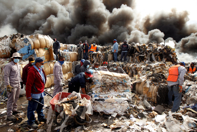 멕시코 주민들이 지난  2일(현지시간) 시우다드후아레스에서 쓰레기를 처리하고 있다. /로이터연합뉴스