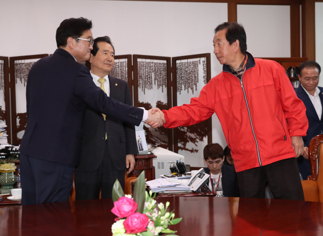 굳은 표정으로 악수하는 우원식과 김성태    4일 오후 국회 의장실에서 열린 국회의장, 교섭단체 원내대표 긴급회동에서 우원식(왼쪽) 더불어민주당 원내대표와 김성태 자유한국당 원내대표가 굳은 표정으로 악수하고 있다./연합뉴스