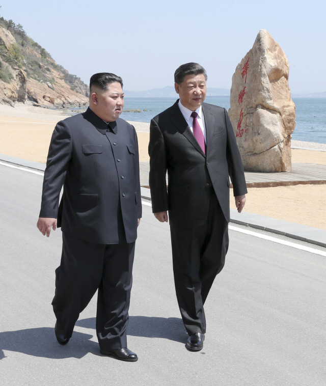 김정은(왼쪽) 북한 국무위원장과 시진핑 중국 국가주석이 8일 중국 다롄의 휴양지 방추이다오 해안가를 거닐며 대화를 나누고 있다./다롄=신화연합뉴스