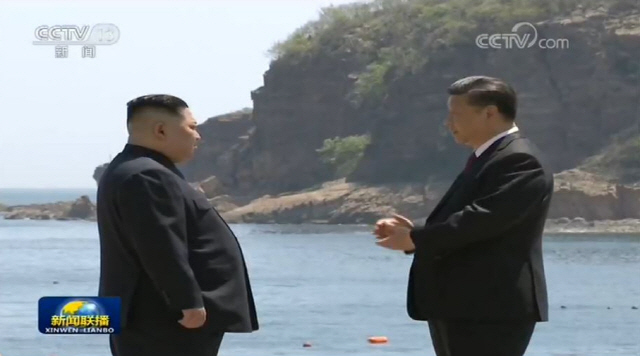 김정은 북한 국무위원장과 시진핑 중국 주석이 중국 다롄의 휴양지 방추이다오 해안가를 거닐며 대화를 나누고 있다. /중국중앙(CC)TV 캡처=연합뉴스