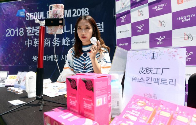 중국의 뷰티 전문 왕훙인 웨이즈웨이가 9일 한중 비즈니스포럼이 열린 서울 장충동 신라호텔에서 중국 시청자들을 대상으로 한국 화장품을 소개하는 인터넷 생방송을 진행 중이다. /이호재기자