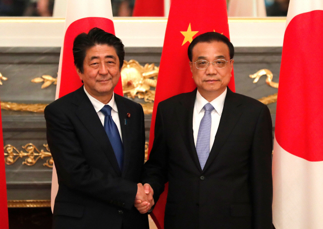 아베 신조(왼쪽) 일본 총리와 리커창 중국 총리가 9일 도쿄 아카사카 궁 영빈관에서 양자회담을 시작하며 악수하고 있다.   /도쿄=AFP연합뉴스
