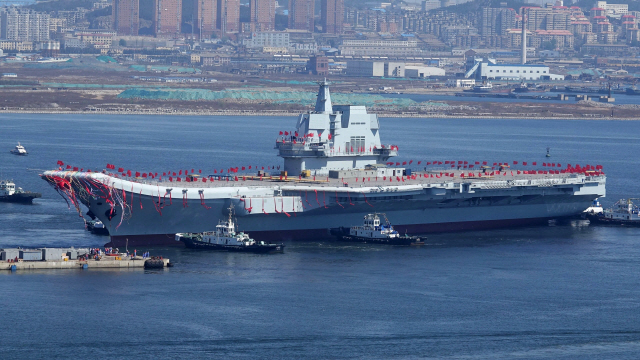 중국이 자체기술로 건조한 첫 번째 항공모함인 ‘001A’함이 진수식이 이뤄진 지 1년여만인 13일 시운항에 들어갔다. 사진은 지난해 4월 26일 드라이 독(건선구)에서 건조된 뒤 바다 위 부두로 옮겨지는 모습.  /베이징 AFP=연합뉴스