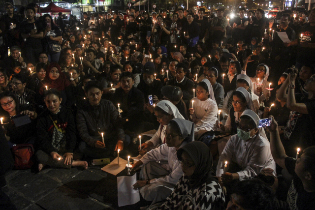 인도네시아 시민들이 13일(현지시간) 수라바야에서 발생한 기독교 교회 폭탄 테러 희생자들의 넋을 위로하고 있다. /수라바야=AP연합뉴스