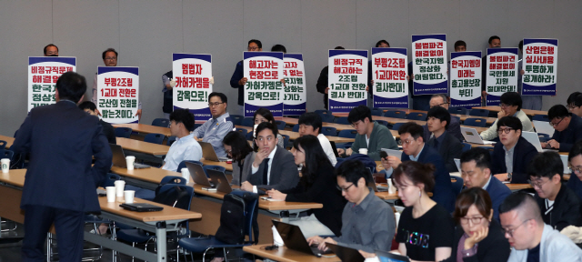 4일 오전 인천시 부평구 한국지엠(GM) 부평공장 홍보관에서 열린 ‘한국지엠 경영 정상화 기자간담회’에서 한국지엠 비정규직 노조원들이 손팻말을 들고 시위하고 있다. 이날 열리기로 한 기자간담회는 취소됐다./연합뉴스