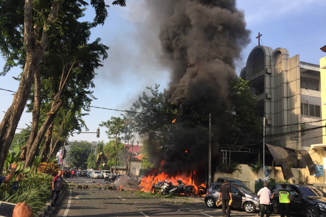 13일(현지시간) 인도네시아 동자바 주도 수라바야 도심에서 발생한 자살폭탄 테러로 지역경찰본부 일대가 화염에 휩싸이고 있다. /수라바야=AFP연합뉴스