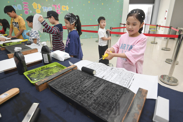 15일 서울 용산구 국립한글박물관에서 열린 제621돌 세종대왕 탄신일 기념행사 '세종, 함께 걷다'에서 아이들이 훈민정음 언해본 서문과 용비어천가를 직접 인쇄하는 목판인쇄 체험을 하고 있다./송은석기자