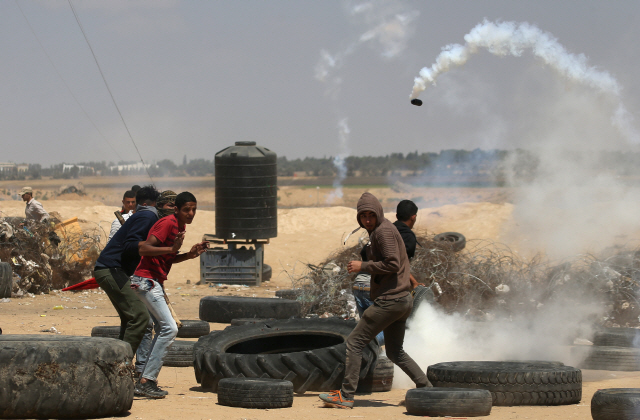 ‘나크바’(대재앙) 70주년인 15일(현지시간) 팔레스타인 시위자들이 가자지구에서 이스라엘군이 발사한 최루가스를 피하고 있다. /가자=로이터연합뉴스