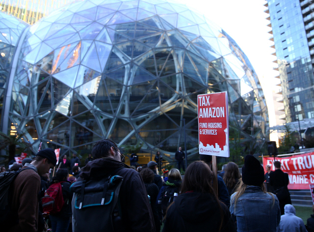 4월 11일(현지시간) 미국 시애틀시에 잇는 미 최대 전자상거래업체 ‘아마존’ 본사 앞에서 시위자들이 “아마존에 과세하라”는 피켓을 들고 있다. /시애틀=로이터연합뉴스