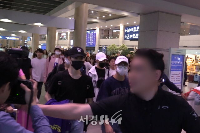 멤버들이 지켜보고 있는 상황에서 경호원이 한 매체 사진기자의 카메라를 내리치고 있다. /사진 - 라이브엔 영상 캡처 제공