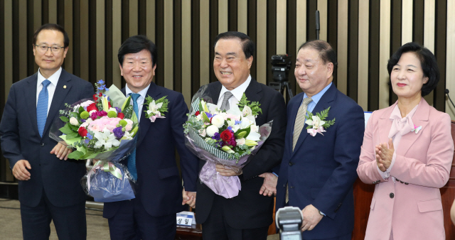 16일 오전 국회에서 열린 더불어민주당 의원총회에서 20대 국회 후반기 국회의장 후보로 선출된 문희상 의원이 축하 꽃다발을 받고 포즈를 취하고 있다. 왼쪽부터 홍영표 원내대표, 박병석 의원, 문희상 의원, 강창일 의원, 추미애 대표./연합뉴스