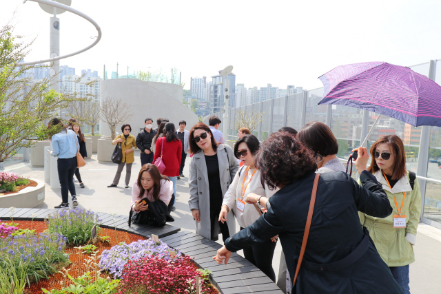 서울로7017을 찾은 시민들이 인공지반 위에 핀 꽃을 구경하고 있다. /사진제공=서울시