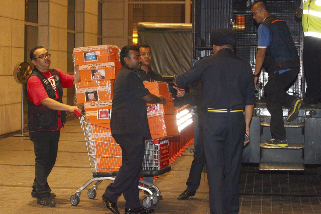 18일(현지시간) 말레이시아 경찰이 쿠알라룸푸르에 있는 나집 라작 전 말레이시아 총리와 관련이 있는 아파트에서 압수한 물품을 트럭에 싣고 있다. 경찰은 지난 16일 밤부터 나집 전 총리의 집과 가족 등의 아파트를 수색해 수백 개의 명품 핸드백과 시계, 현금, 귀금속을 압수한 것으로 알려졌다. /쿠알라룸푸르=AP연합뉴스