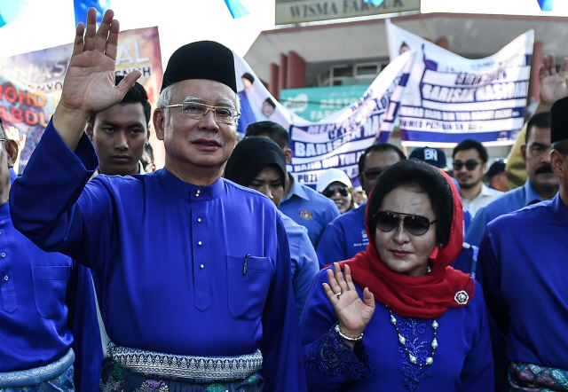 나집 라작 전 말레이시아 총리가 지난달 28일 페칸에서 열린 선거 행사에서 부인 로스마 만소르 여사와 함께 지지자들을 향해 손을 흔들고 있다. /페칸=AFP연합뉴스