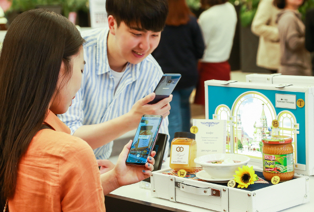 방문객들이 서울 강남 파미에스테이션에 마련된 ‘갤럭시 스튜디오’에서 카메라만 대면 각국의 요리, 메뉴판, 와인, 관광명소, 식재료 등의 정보 확인이 바로 가능한 ‘빅스비 비전’을 체험하고 있다. /사진제공=삼성전자