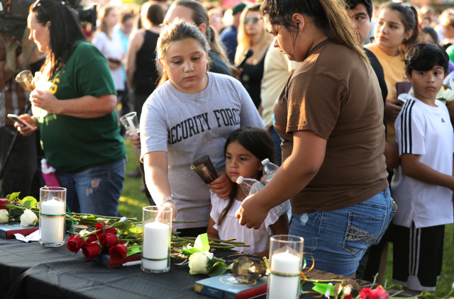 18일(현지시간) 미 텍사스주 산타페시 산타페고교에서 발생한 총기난사로 숨진 사람들을 추모하기 위해 사람들이 장미꽃을 헌화하고 있다. /산타페=로이터연합뉴스