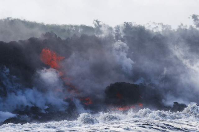 Lava flows into the ocean near Pahoa, Hawaii, Sunday, May 20, 2018. Kilauea volcano that is oozing, spewing and exploding on Hawaii‘s Big Island has gotten more hazardous in recent days, with rivers of molten rock pouring into the ocean Sunday and flying lava causing the first major injury. (AP Photo/Jae C. Hong)      <저작권자(c) 연합뉴스, 무단 전재-재배포 금지>