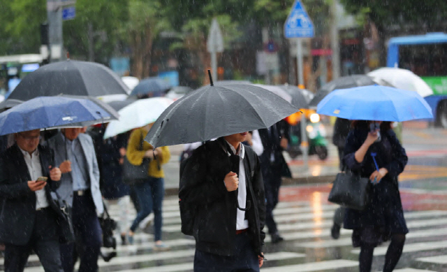 지난 16일 오전 서울 광화문 세종대로 사거리에서 우산을 쓴 출근길 시민들이 발걸음을 옮기고 있다. /연합뉴스