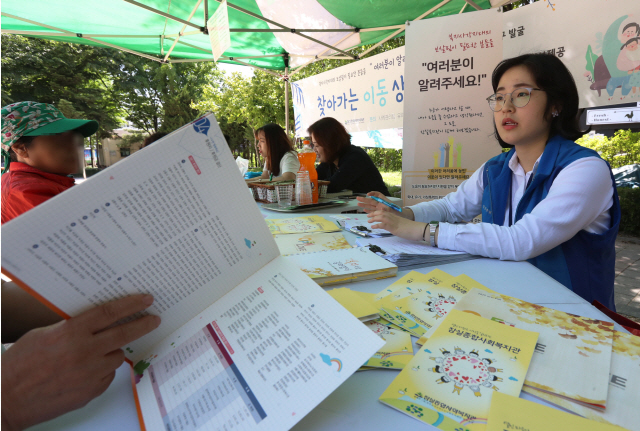 지난 23일 서울 송파구 잠실 근린공원에서 사회복지사들이 저소득 주민들을 대상으로 상담을 하고 있다.  /연합뉴스