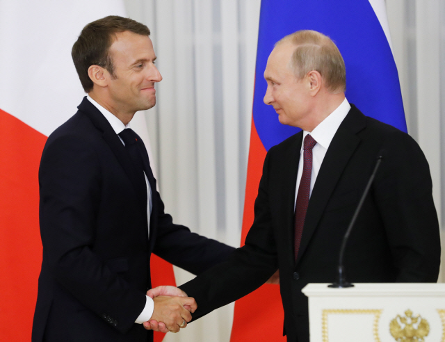 에마뉘엘 마크롱(왼쪽) 프랑스 대통령과 블라디미르 푸틴 러시아 대통령이 24일(현지시간) 러시아 상트페테르부르크에서 열린 회담에서 악수하고 있다. /상트페테르부르크=타스연합뉴스