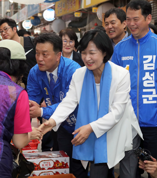 추미애(앞줄 오른쪽) 더불어민주당 대표가 25일 오후 부산 해운대구 반송시장을 찾아 윤준호(〃 왼쪽) 해운대 국회의원 후보와 함께 주민과 악수하며 지지를 당부하고 있다. /연합뉴스