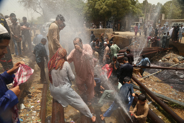 파키스탄 카라치의 고장난 급수관 주변에서 사람들이 더위를 식히고 있다. /EPA연합뉴스