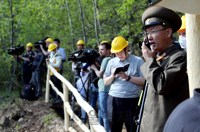 24일 북한 핵무기연구소 관계자들이 함경북도 길주군 풍계리 핵실험장 폐쇄를 위한 폭파 작업을 했다. 핵무기연구소 관계자가 갱도 폭파에 앞서 무선 교신을 하고 있다.  /사진공동취재단