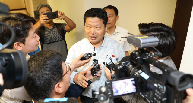 28일 오전 싱가포르 주재 북한대사관 앞에서 자신을 이 서기관이라고 밝힌 관계자가 국내 기자들의 북미회담 관련 질문을 받고 있다./연합뉴스