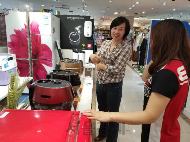 현지 소비자가 중국 상하이 징팅다사 백화점의 대우전자 매장에서 대유위니아 ‘딤채쿡’ 밥솥을 살펴보고 있다. /사진제공=대우전자