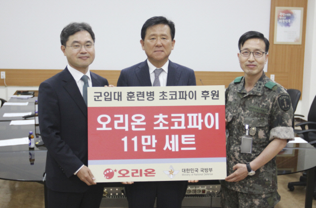 29일 논산 육군훈련소에서 개최된 ‘국군장병과 함께하는 오리온 초코파이 정 전달식’에서 오리온 이경재 사장(가운데)이 이남우 국방부 인사복지실장(왼쪽)과 구재서 육군훈련소장에게 후원증서를 전달하고 있다./출처=국방부 제공