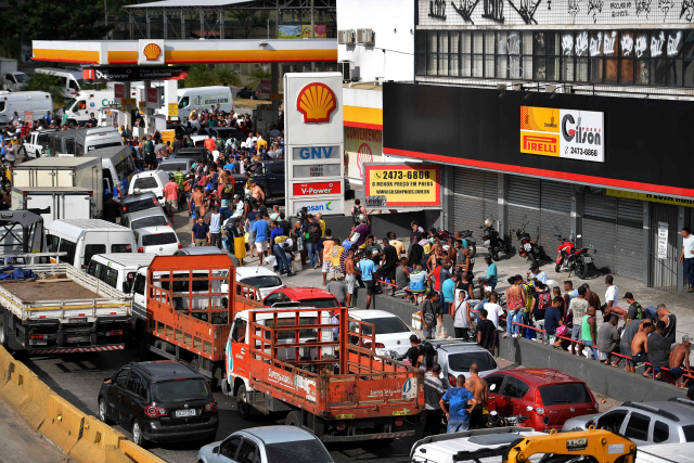 디젤 가격 인상에 항의하는 브라질 트럭 운전사들의 파업이 8일째 계속되는 가운데 28일(현지시간) 리우데자네이루의 한 주유소에 기름을 넣기 위한 차량과 사람들이 장사진을 치고 있다.  　  /리우데자네이루=AFP연합뉴스