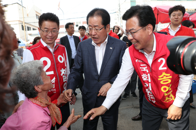 자유한국당 홍준표(가운데) 대표가 30일 이철우(왼쪽) 경북도지사 후보 등과 함께 경북 김천 황금시장을 방문해 시민들과 인사하고 있다. /연합뉴스