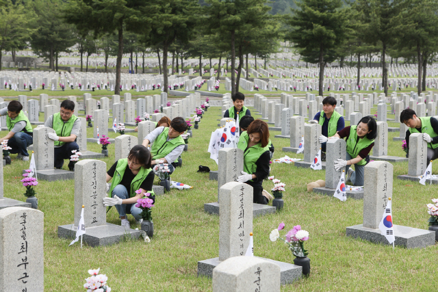 LIG넥스원 임직원들이 6월 호국 보훈의 달을 맞아 지난 29일 서울 동작구 국립서울현충원에서 묘역 정화활동을 실시하고 있다. /사진제공=LIG넥스원