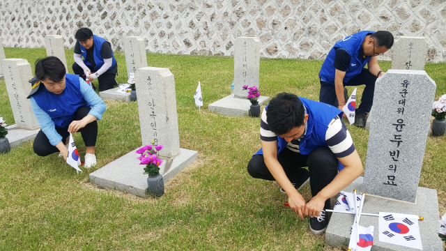 현대로템 직원들이 호국보훈의 달을 맞아 지난 29일 서울시 동작구에 위치한 국립서울현충원에서 순국선열 모역에 태극기를 꽂는 등 봉사활동을 실시하고 있다. /사진제공=현대로템